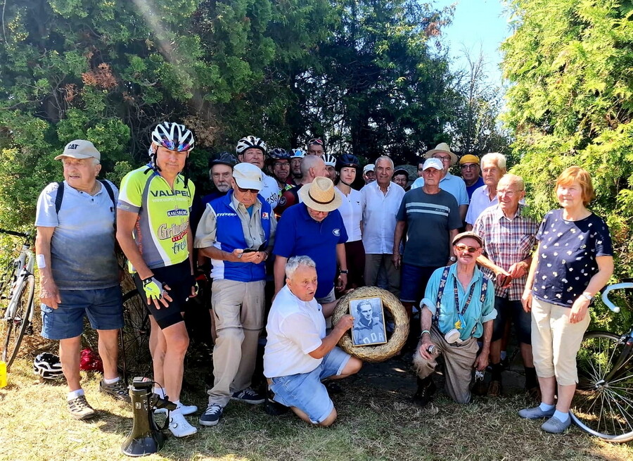 Etwa 20 aktive und ehemalige Radsportler versammeln sich zur Gedenkfeier am Gedenkstein bei Rollsdorf