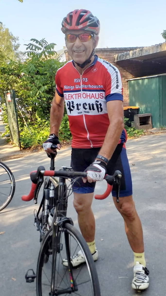 Raimund Dinter in Vereinskleidung mit seinem Rennrad