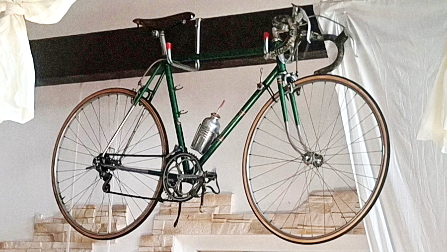 Historisches grünes Rennrad, unter der Decke hängend ausgestellt