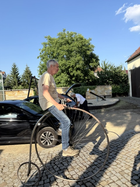 Besucher probiert ein historisches Hochrad vor dem Velocium aus