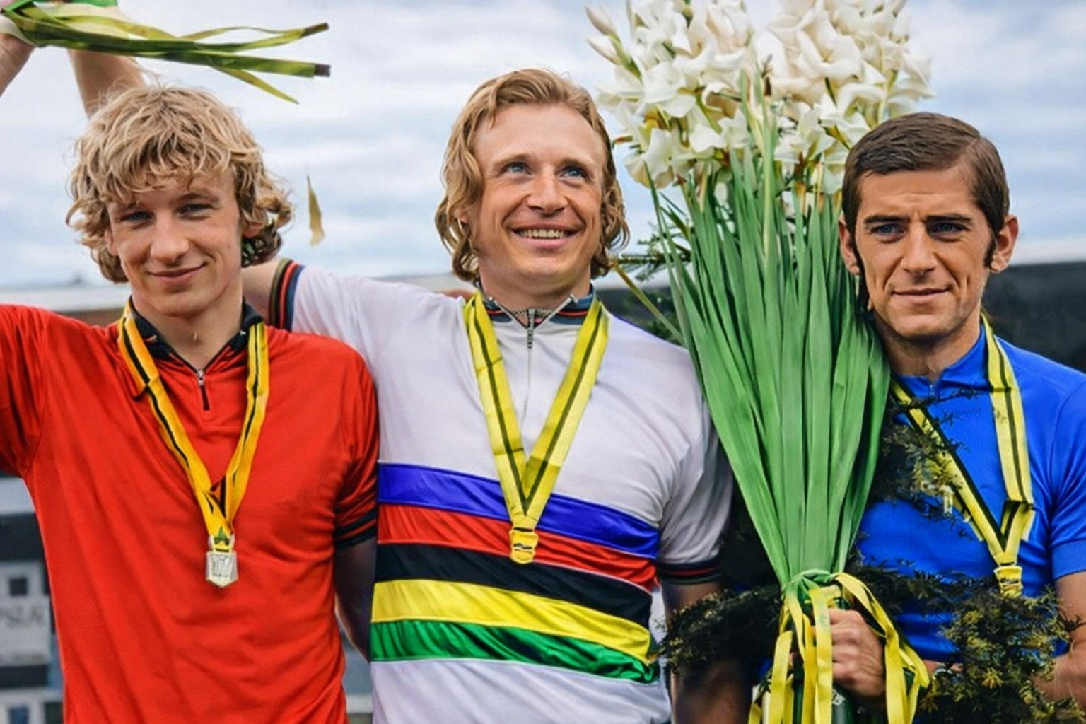 Drei Medaillengewinner mit Blumen bei einer Siegerehrung, in der Mitte Thomas Huschke im Weltmeistertrikot